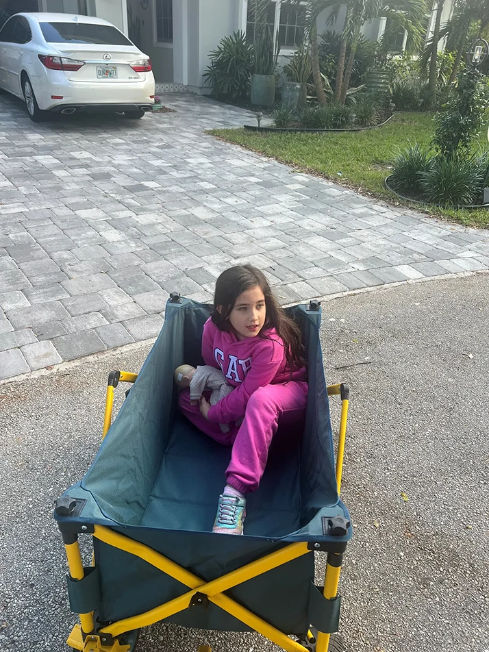 Little Girl Seated in Nylon Wagon